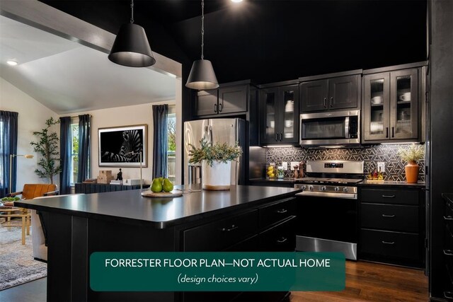 3001 Red Cedar Way, Norman, OK 73069 - kitchen with appliances with stainless steel finishes, vaulted ceiling, decorative backsplash, dark countertops, and a kitchen island