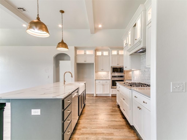 8525 Maple Creek Rd, Arcadia, OK 73007 - kitchen with appliances with stainless steel finishes, decorative backsplash, light wood finished floors, white cabinetry, and beamed ceiling
