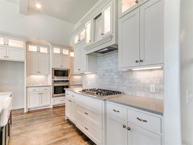 8525 Maple Creek Rd, Arcadia, OK 73007 - kitchen featuring appliances with stainless steel finishes, white cabinetry, decorative backsplash, light wood-style flooring, and recessed lighting