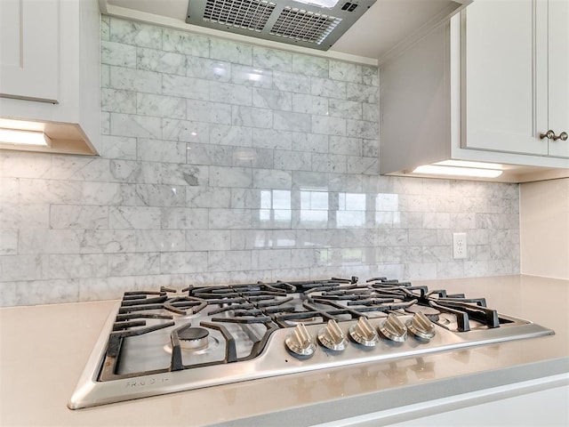 8525 Maple Creek Rd, Arcadia, OK 73007 - kitchen view of stainless steel gas stovetop, range hood, light countertops, backsplash, and white cabinets