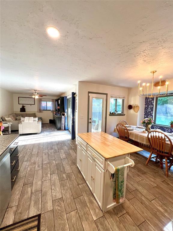 5704 N Warren Ave, Oklahoma City, OK 73112 - kitchen with dark wood finished floors, a chandelier, butcher block countertops, open floor plan, and a ceiling fan