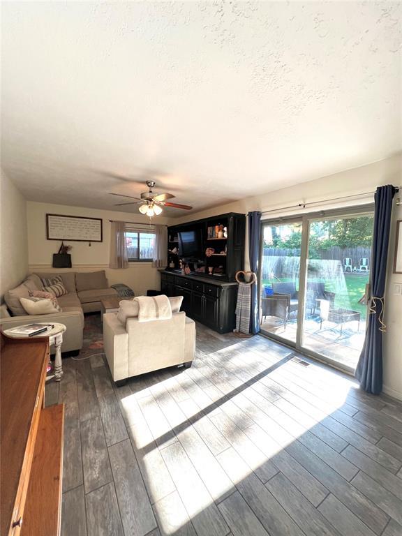 5704 N Warren Ave, Oklahoma City, OK 73112 - living area featuring wood finished floors, ceiling fan, and a textured ceiling