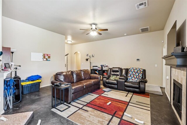 1012 SW 13th St, Moore, OK 73160 - living room featuring finished concrete floors, a ceiling fan, arched walkways, a fireplace, and baseboards