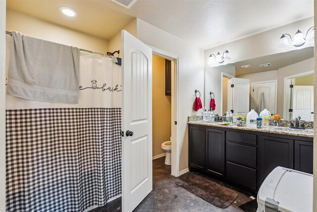 1012 SW 13th St, Moore, OK 73160 - bathroom with toilet, double vanity, concrete flooring, curtained shower, and recessed lighting