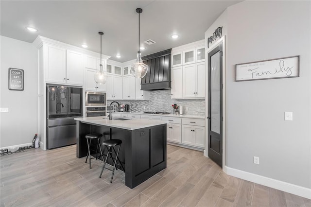 5808 Ledgestone Dr, Mustang, OK 73064 - kitchen featuring stainless steel appliances, a sink, light countertops, a kitchen breakfast bar, and white cabinetry