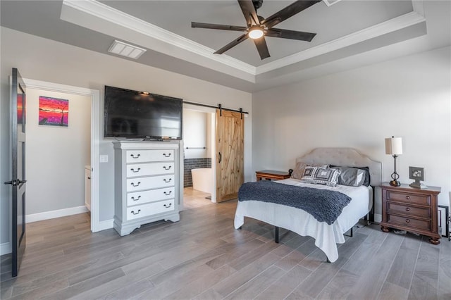 5808 Ledgestone Dr, Mustang, OK 73064 - bedroom featuring a tray ceiling, a barn door, light wood-type flooring, and crown molding