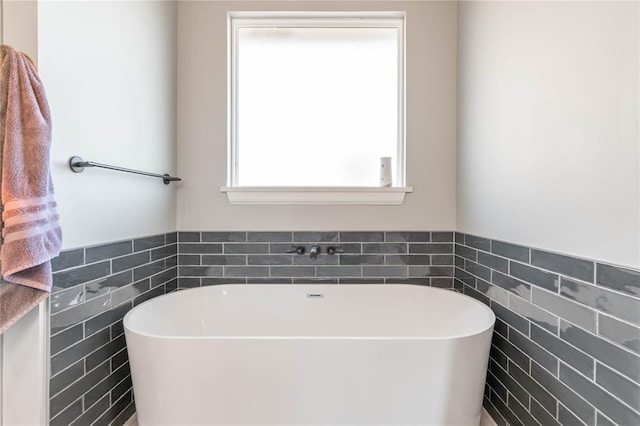 5808 Ledgestone Dr, Mustang, OK 73064 - full bathroom with tile walls, a freestanding tub, and a wainscoted wall