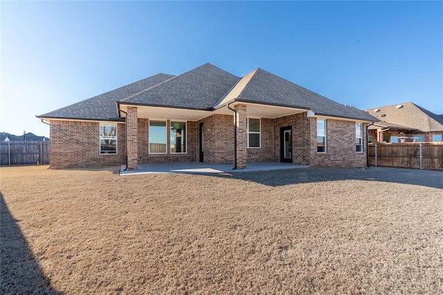 5808 Ledgestone Dr, Mustang, OK 73064 - rear view of house with roof with shingles, a fenced backyard, and brick siding