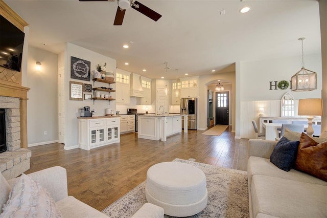 1508 Station St, Edmond, OK 73034 - living room featuring a ceiling fan, arched walkways, a fireplace, hardwood / wood-style flooring, and recessed lighting