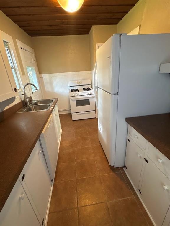 408 N Findlay St, Norman, OK 73071 - kitchen with white appliances, wooden ceiling, a sink, a wainscoted wall, and dark tile patterned floors