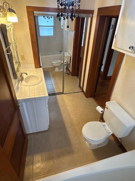 408 N Findlay St, Norman, OK 73071 - full bath featuring toilet, a textured wall, vanity, tile patterned floors, and a chandelier