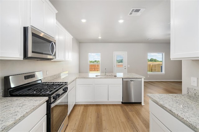 5410 Mac Rd, Tuttle, OK 73089 - kitchen featuring appliances with stainless steel finishes, a sink, light wood-type flooring, a peninsula, and healthy amount of natural light