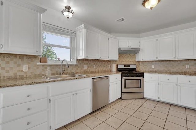 2 NW Havenshire Cir, Lawton, OK 73505 - kitchen with appliances with stainless steel finishes, a sink, under cabinet range hood, light tile patterned floors, and white cabinets