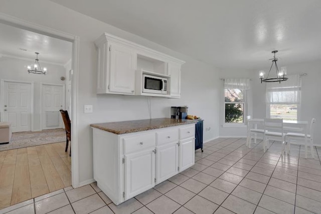 2 NW Havenshire Cir, Lawton, OK 73505 - kitchen featuring a chandelier, white microwave, baseboards, light tile patterned floors, and white cabinetry