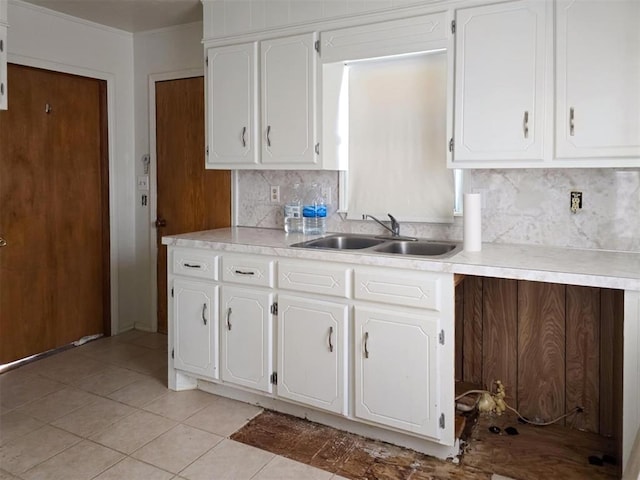226 E Iowa St, Walters, OK 73572 - kitchen with a sink, white cabinetry, tasteful backsplash, light countertops, and ornamental molding