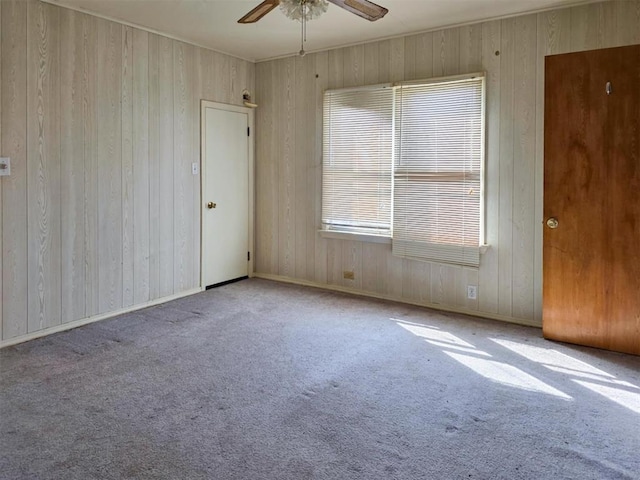 226 E Iowa St, Walters, OK 73572 - carpeted empty room with ceiling fan and wood walls