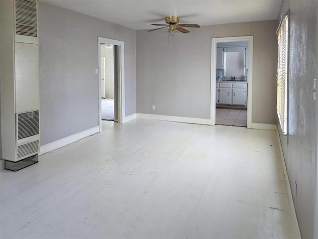 226 E Iowa St, Walters, OK 73572 - unfurnished room featuring a heating unit, a ceiling fan, baseboards, and a sink