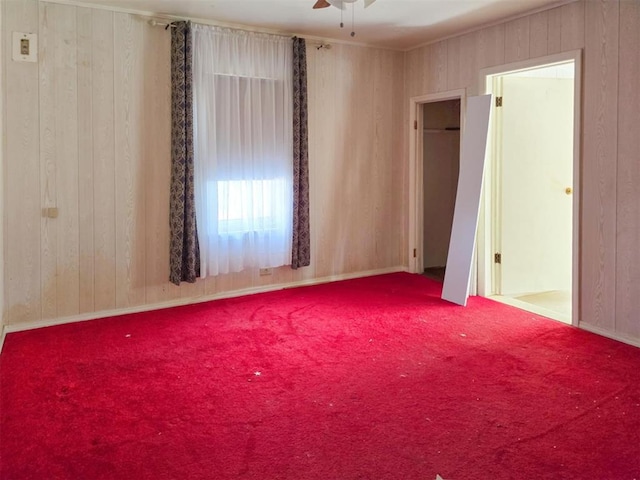 226 E Iowa St, Walters, OK 73572 - carpeted spare room with wood walls, ceiling fan, and baseboards