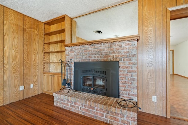 1317 S 58th St, Duncan, OK 73534 - detailed view of wood finished floors, a textured ceiling, a fireplace, built in shelves, and wood walls