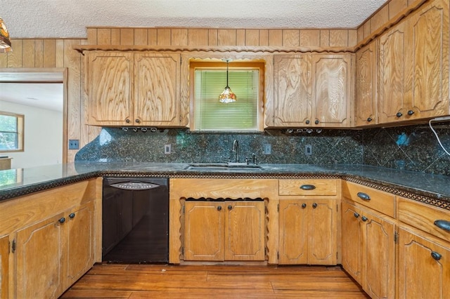 1317 S 58th St, Duncan, OK 73534 - kitchen with black dishwasher, a sink, tasteful backsplash, wood finished floors, and a textured ceiling