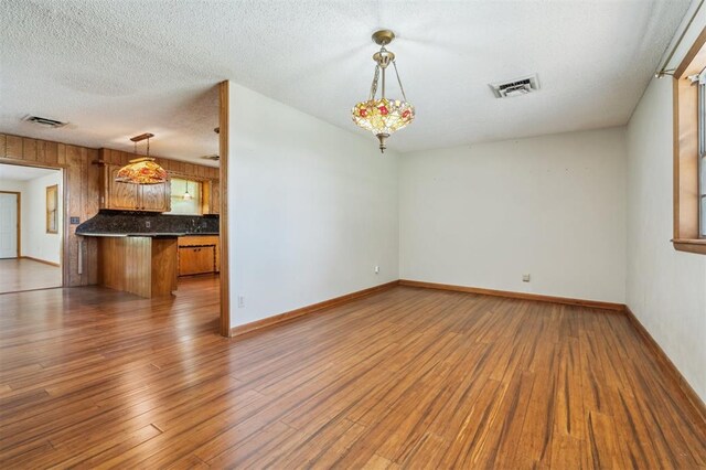 1317 S 58th St, Duncan, OK 73534 - unfurnished living room featuring wood finished floors, a textured ceiling, and baseboards