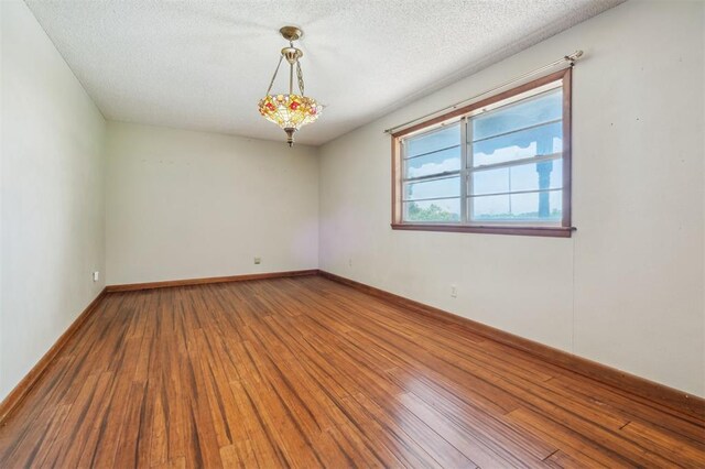 1317 S 58th St, Duncan, OK 73534 - empty room with hardwood / wood-style floors, a textured ceiling, and baseboards