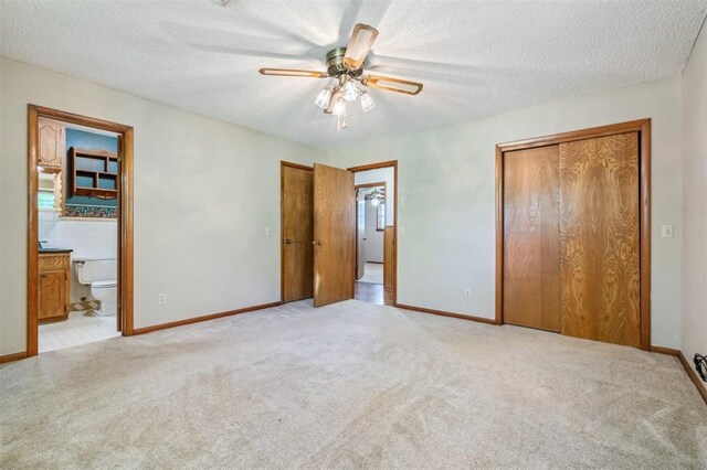1317 S 58th St, Duncan, OK 73534 - unfurnished bedroom featuring carpet floors, baseboards, a textured ceiling, a ceiling fan, and ensuite bathroom