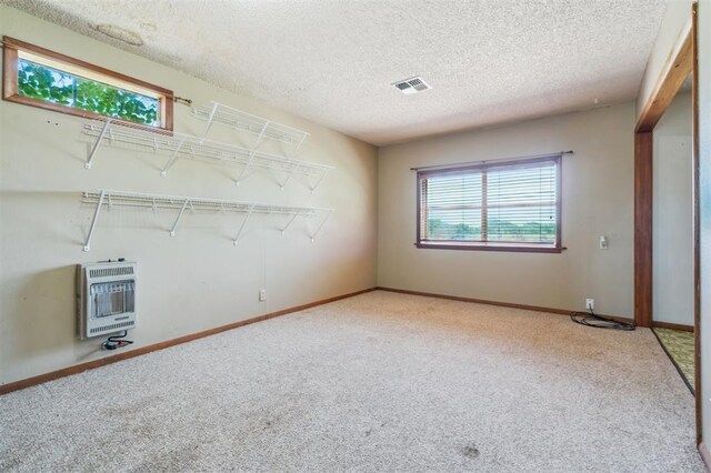 1317 S 58th St, Duncan, OK 73534 - carpeted spare room with heating unit, a textured ceiling, and baseboards