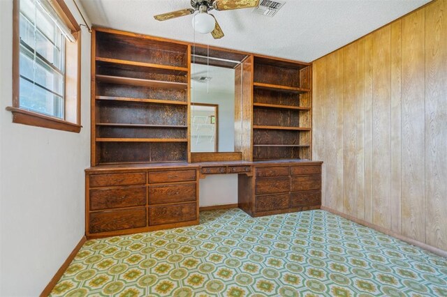 1317 S 58th St, Duncan, OK 73534 - unfurnished office featuring wood walls, built in study area, a ceiling fan, baseboards, and a textured ceiling