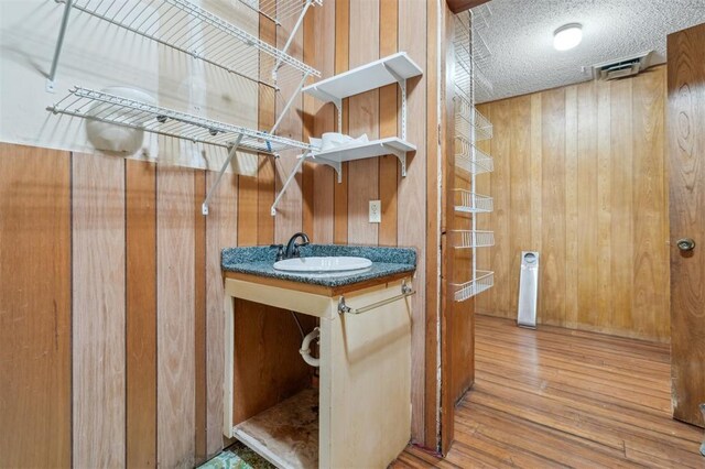 1317 S 58th St, Duncan, OK 73534 - bathroom with wooden walls, wood finished floors, and vanity