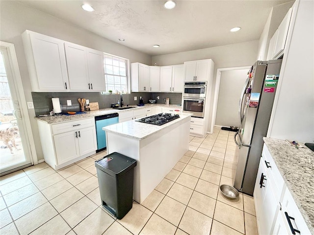 9977 Birkenhead Ct, Yukon, OK 73099 - kitchen with stainless steel appliances, light tile patterned flooring, white cabinets, tasteful backsplash, and recessed lighting