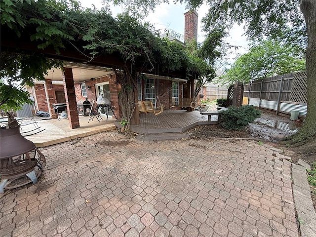 9977 Birkenhead Ct, Yukon, OK 73099 - rear view of house with brick siding, a deck, and a patio area