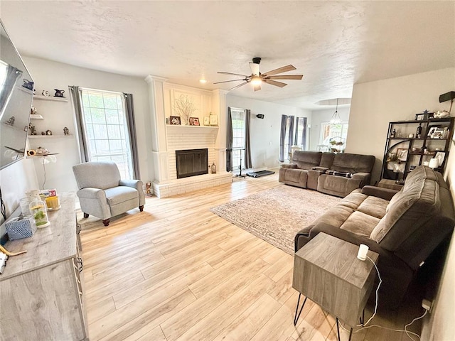 9977 Birkenhead Ct, Yukon, OK 73099 - living room with light wood-style floors, ceiling fan, and a fireplace