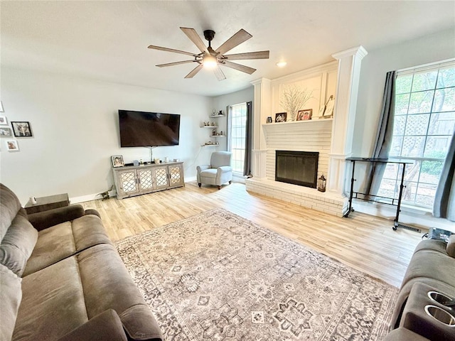 9977 Birkenhead Ct, Yukon, OK 73099 - living room with a ceiling fan, wood finished floors, healthy amount of natural light, and a brick fireplace