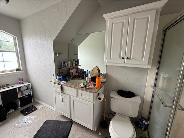 9977 Birkenhead Ct, Yukon, OK 73099 - bathroom featuring a textured wall, vanity, a shower stall, and wood finished floors
