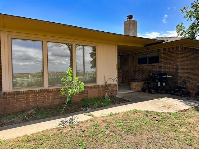 10190 County Road 1310, Fort Cobb, OK 73038 - doorway to property with brick siding, a chimney, and a patio area