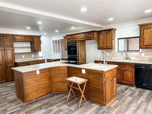 10190 County Road 1310, Fort Cobb, OK 73038 - kitchen with black appliances, a sink, a center island, wood finished floors, and decorative backsplash