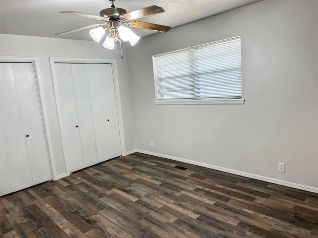 10190 County Road 1310, Fort Cobb, OK 73038 - unfurnished bedroom featuring two closets, dark wood finished floors, and baseboards