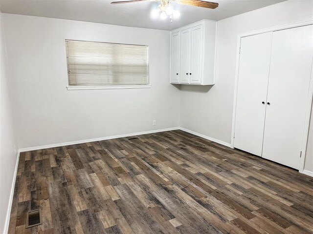 10190 County Road 1310, Fort Cobb, OK 73038 - unfurnished bedroom featuring dark wood finished floors, baseboards, ceiling fan, and a closet