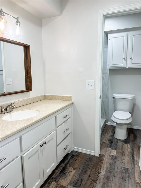 10190 County Road 1310, Fort Cobb, OK 73038 - full bathroom with vanity, wood finished floors, toilet, a stall shower, and baseboards