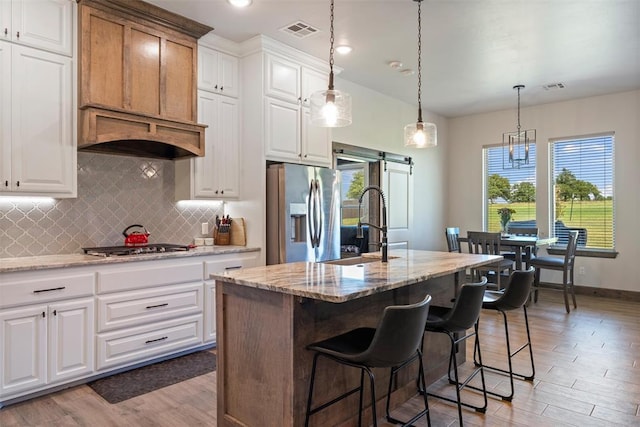 971 County St Unit 2983, Blanchard, OK 73010 - kitchen with stainless steel appliances, a sink, a barn door, backsplash, and light stone countertops