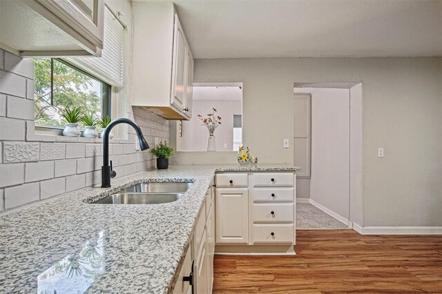 940 NE 32nd St, Oklahoma City, OK 73105 - kitchen with light wood-style flooring, white cabinets, decorative backsplash, and light stone counters