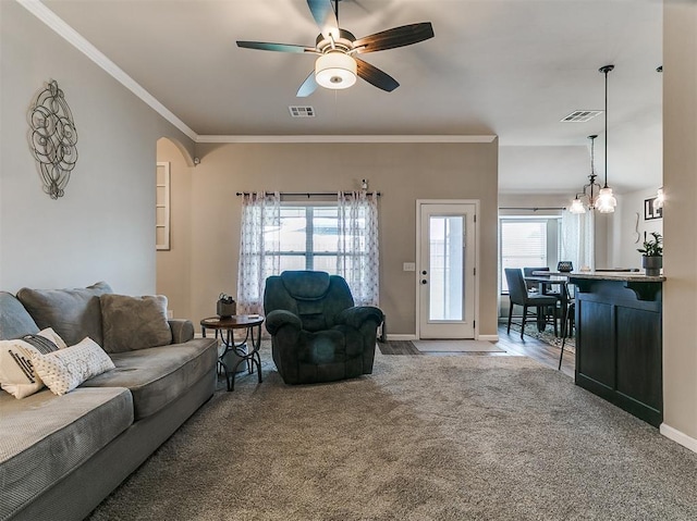 2617 Snapper Ln, Oklahoma City, OK 73130 - living area featuring carpet floors, a ceiling fan, baseboards, crown molding, and arched walkways