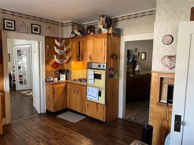 520 S Main St, Wetumka, OK 74883 - kitchen featuring dark wood-type flooring, double wall oven, brown cabinets, and gas cooktop