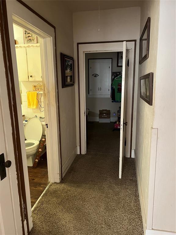 520 S Main St, Wetumka, OK 74883 - corridor featuring dark carpet and baseboards