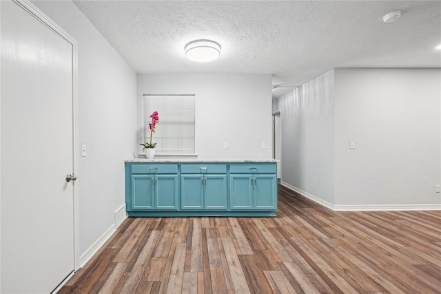 4328 NW 12th St, Oklahoma City, OK 73107 - unfurnished room featuring wood finished floors, a textured ceiling, baseboards, and a smoke detector
