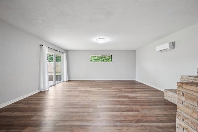4328 NW 12th St, Oklahoma City, OK 73107 - unfurnished room featuring a wall mounted AC, wood finished floors, a textured ceiling, and baseboards