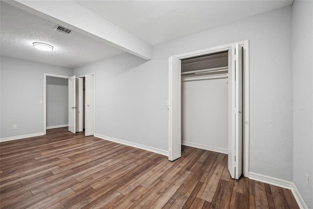 4328 NW 12th St, Oklahoma City, OK 73107 - unfurnished bedroom with wood finished floors, baseboards, a textured ceiling, and a closet