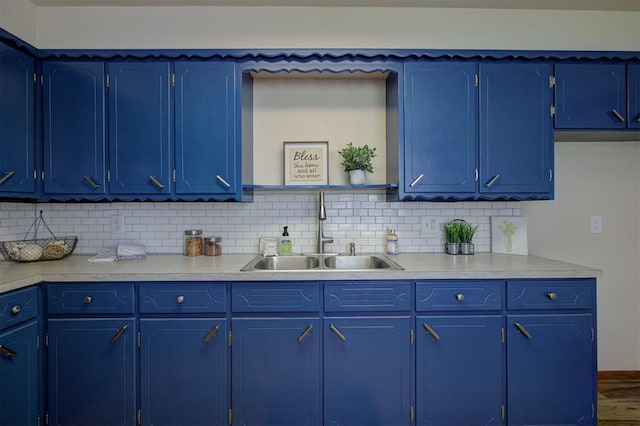 520 SE 47th St, Oklahoma City, OK 73129 - kitchen featuring a sink, light countertops, tasteful backsplash, blue cabinetry, and baseboards
