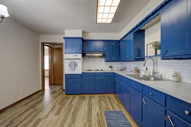 520 SE 47th St, Oklahoma City, OK 73129 - kitchen with a sink, white oven, blue cabinets, and light wood finished floors